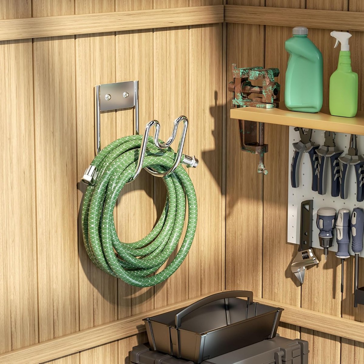 Stainless hose holder mounted on a wooden shed wall holding a coiled green garden hose